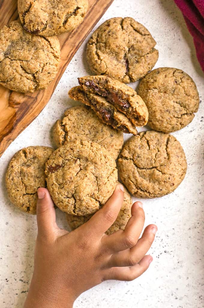 a little hand grabbing a paleo chocolate stuffed cookie