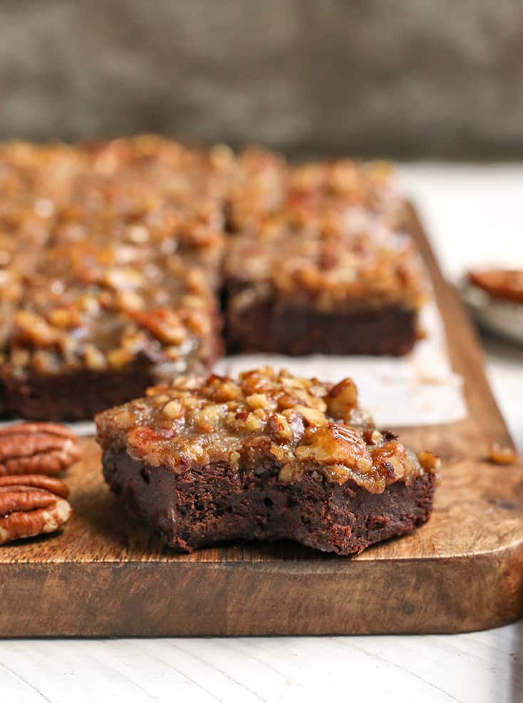 a pecan paleo brownie close up with others behind it