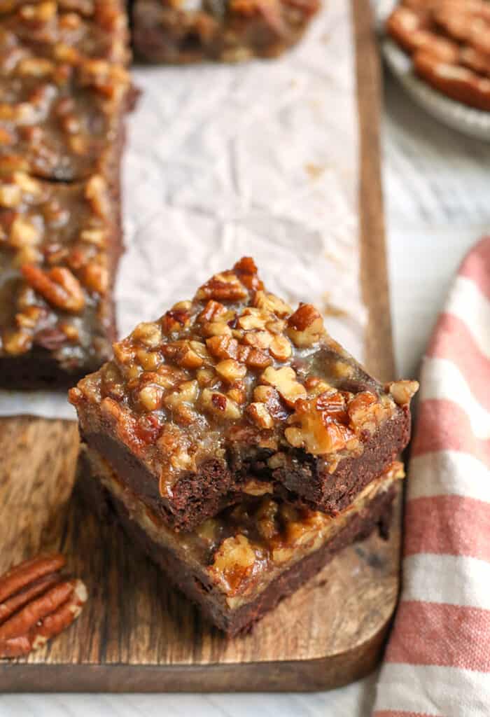 stack of two paleo pecan praline brownies with a bite taken out of the top one