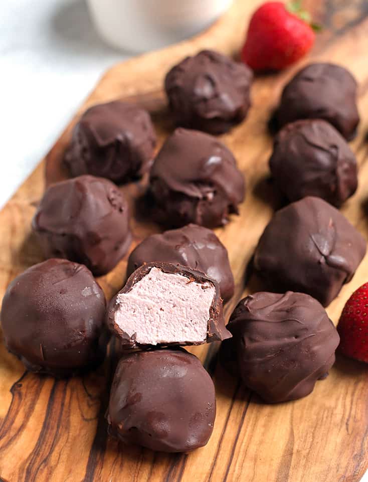 a plate of paleo strawberry cheesecake bites with one cut open to show inside