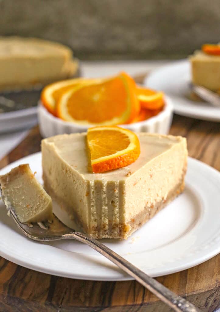 paleo vegan orange creamsicle cheesecake with a bite taken out 