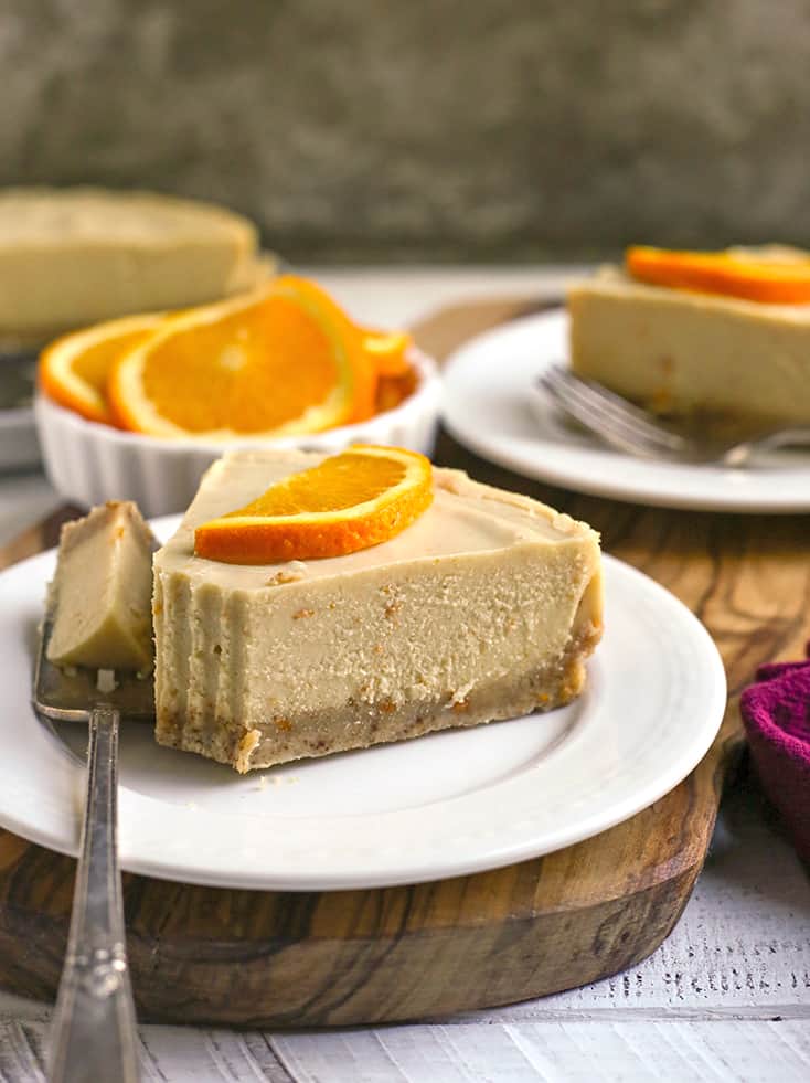 paleo vegan orange creamsicle cheesecake with a bite taken out 