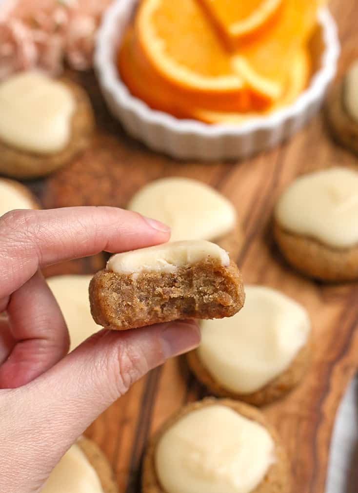 hand holding a paleo vegan orange cookies with a bite taken out