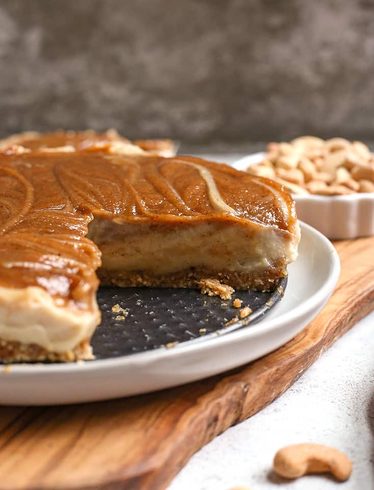 a paleo vegan cinnamon roll cheesecake with a slice missing