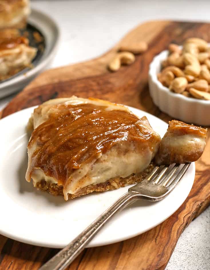 a slice of paleo vegan cinnamon roll cheesecake with a bite taken out 