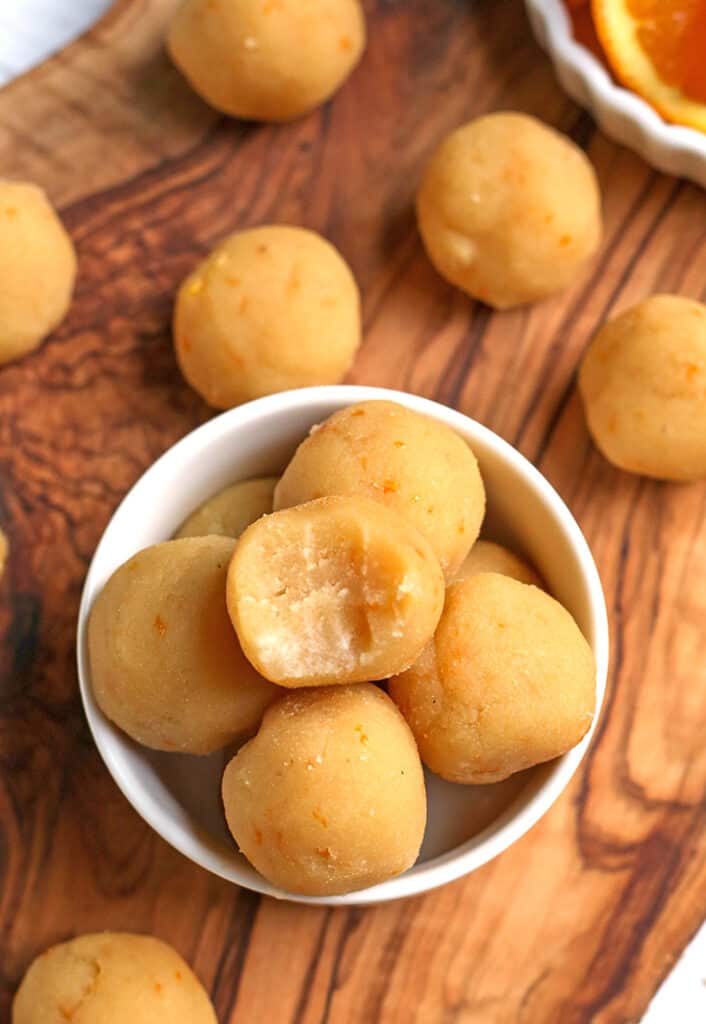 a small bowl with vegan orange bites in it. A bite taken out of the top one. 