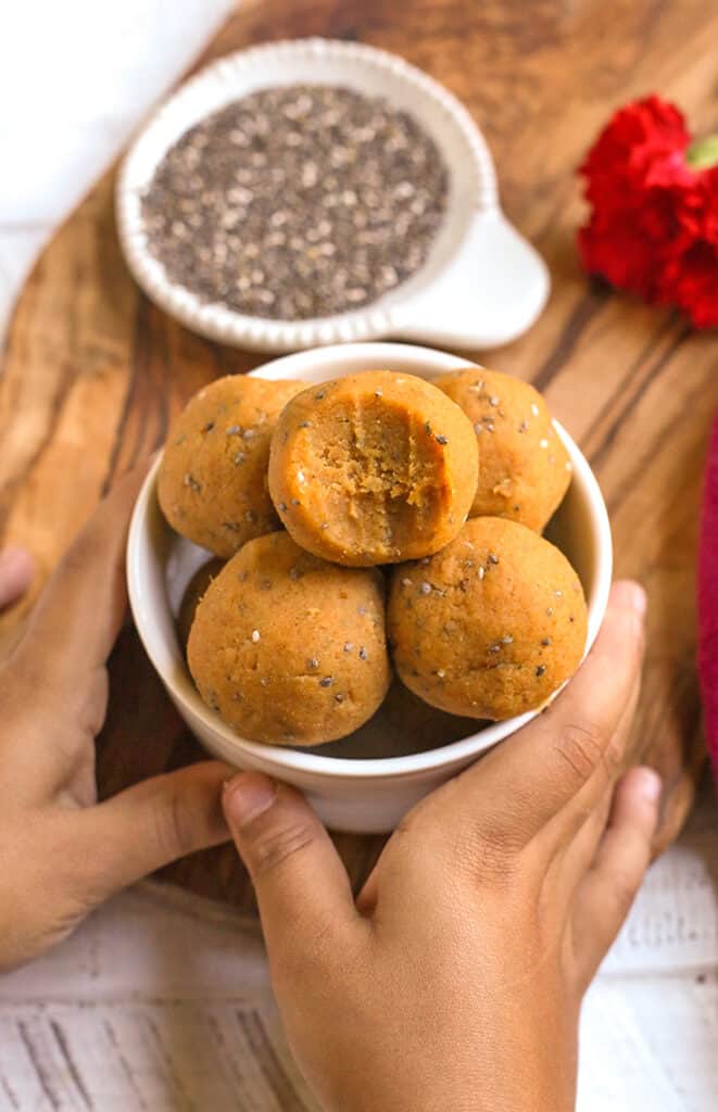 little hands holding a bowl of vegan paleo pumpkin pie bites 