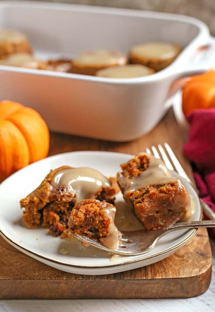 a grain free pumpkin cinnamon roll on a plate with a bite taken out