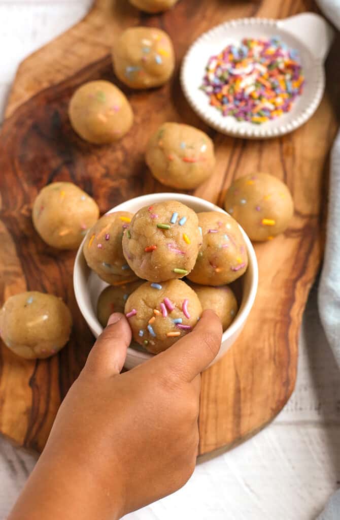 a little hand reaching for a vegan paleo birthday cake bite