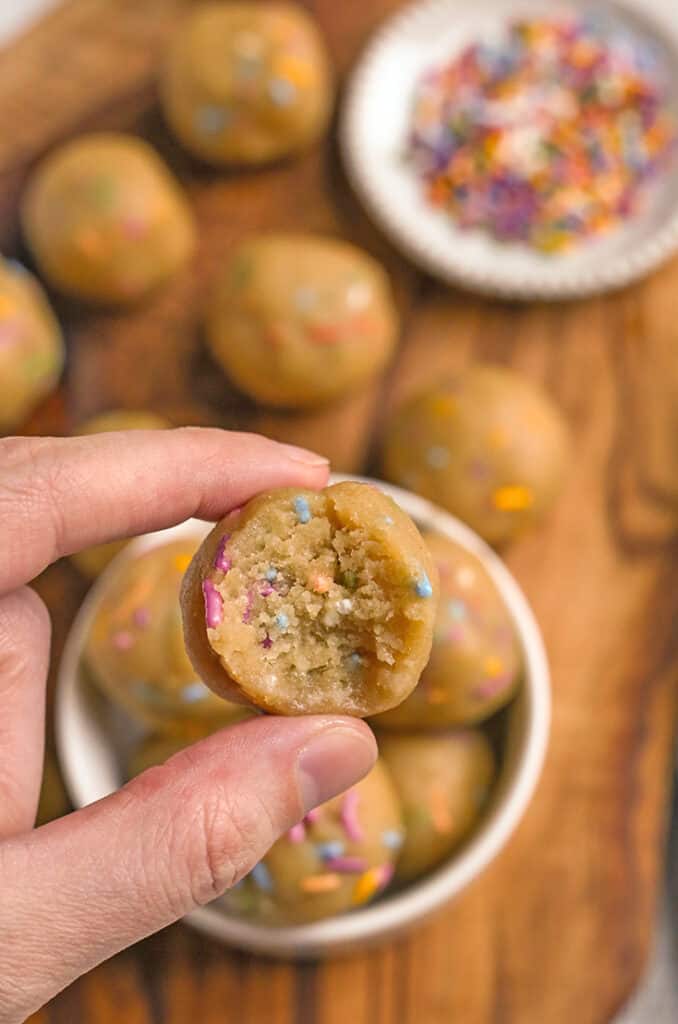 hand holding a paleo vegan birthday cake bites with a bite taken out 