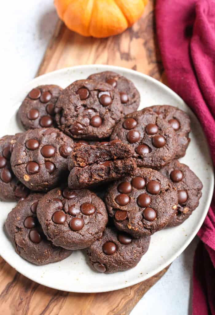 a plate of paleo pumpkin fudge cookies with a bite taken out of two