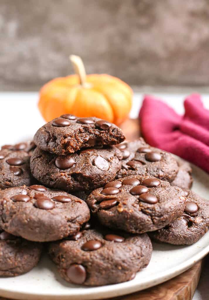 a plate of paleo pumpkin fudge cookies with a bite taken out of the top one