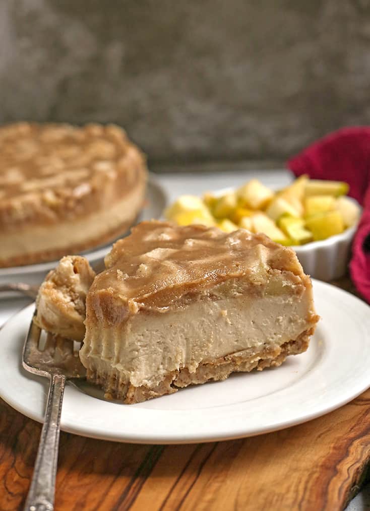 vegan paleo caramel apple cheesecake on a plate with a bite taken out 