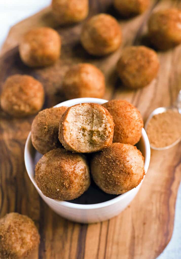 vegan paleo cinnamon roll bites in a bowl with a bite taken out of one