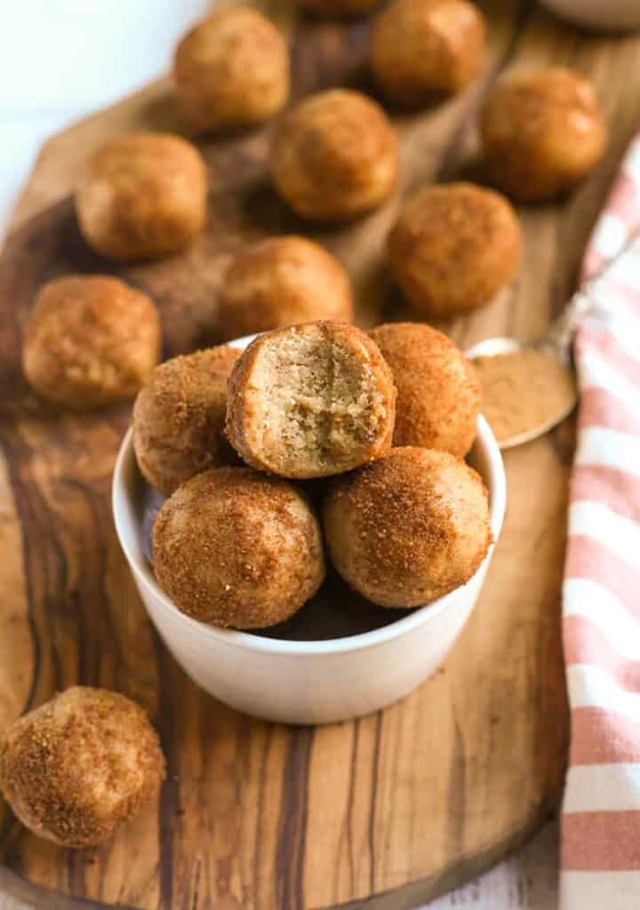 vegan paleo cinnamon roll bites in a bowl with a bite taken out of one 