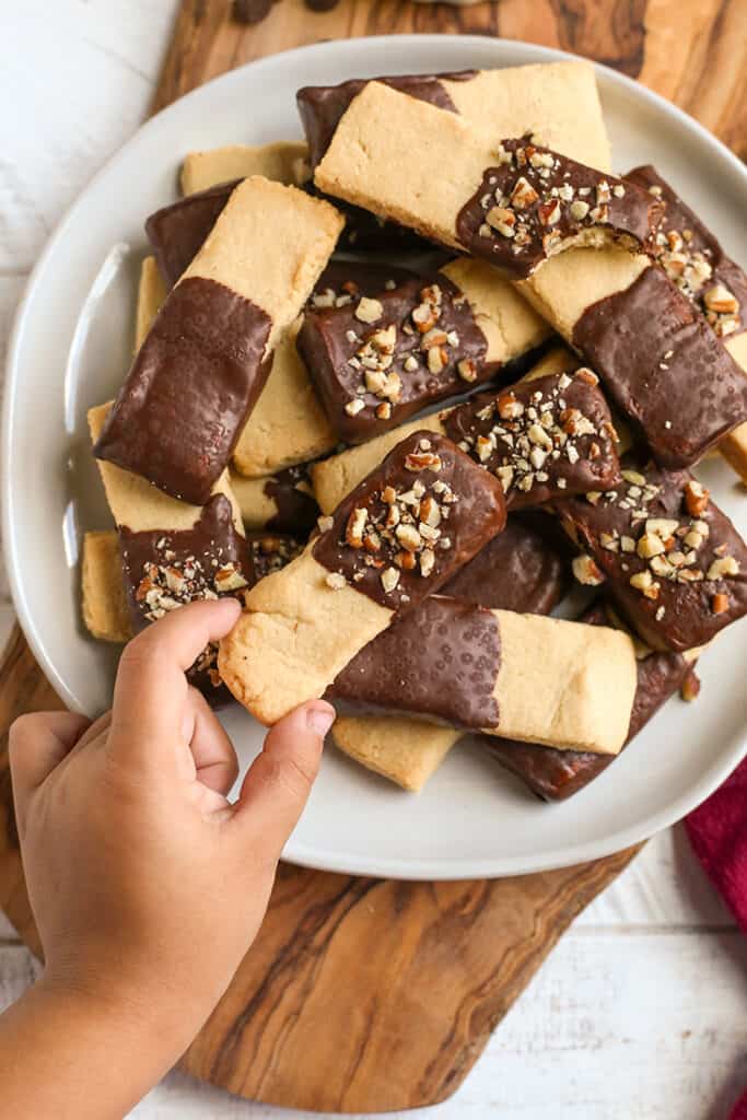 a little hand reaching for a grain free shortbread cookie