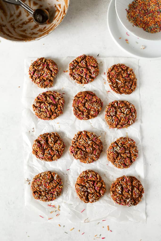 top view of paleo sprinkle cookies showing 12 on some parchment paper 