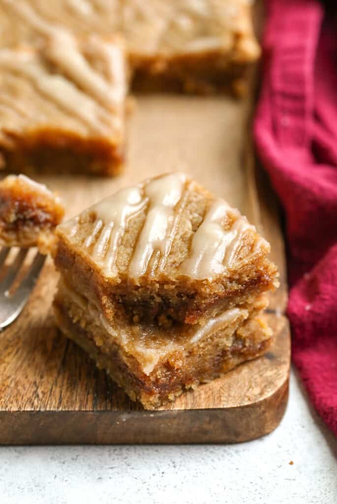 a stack of two paleo cinnamon roll blondies, a bite taken out of the top one