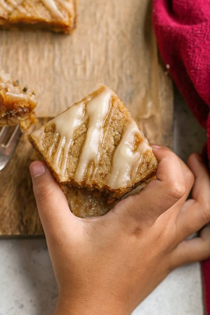 a little hand grabbing a paleo cinnamon roll blondie