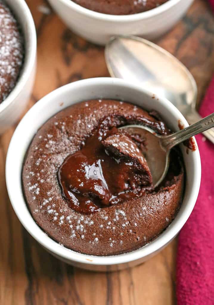 paleo chocolate hot fudge cups with a spoon taking a bite and the gooey center showing 
