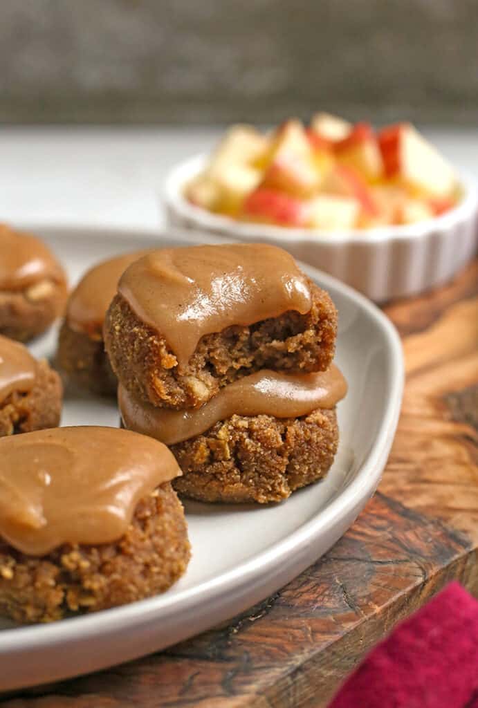 stack of two apple cinnamon cookies on a plate with glaze on top of them