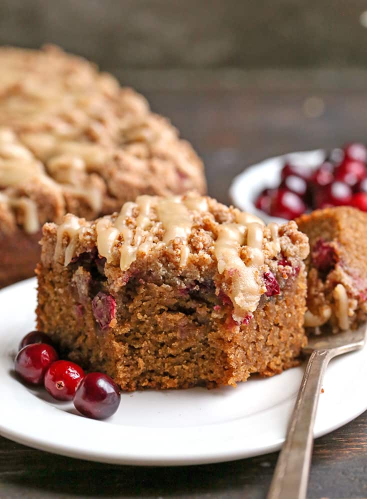 a close shot of a piece of grain free cranberry coffee cake with a bite taken out