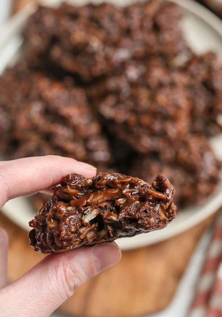 a hand holding a paleo nut free no bake cookie with a bite taken out 