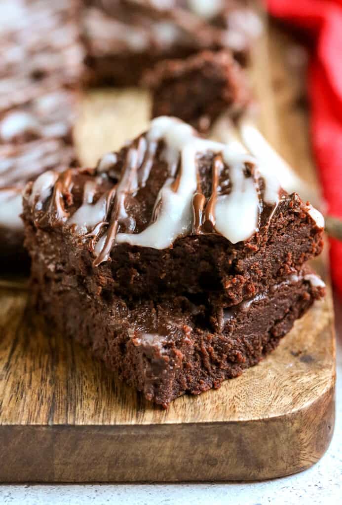 stack of paleo peppermint brownies with a bite taken out of the top one