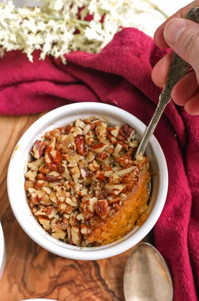 a spoon taking a scoop out of a paleo sweet potato pecan dessert cup