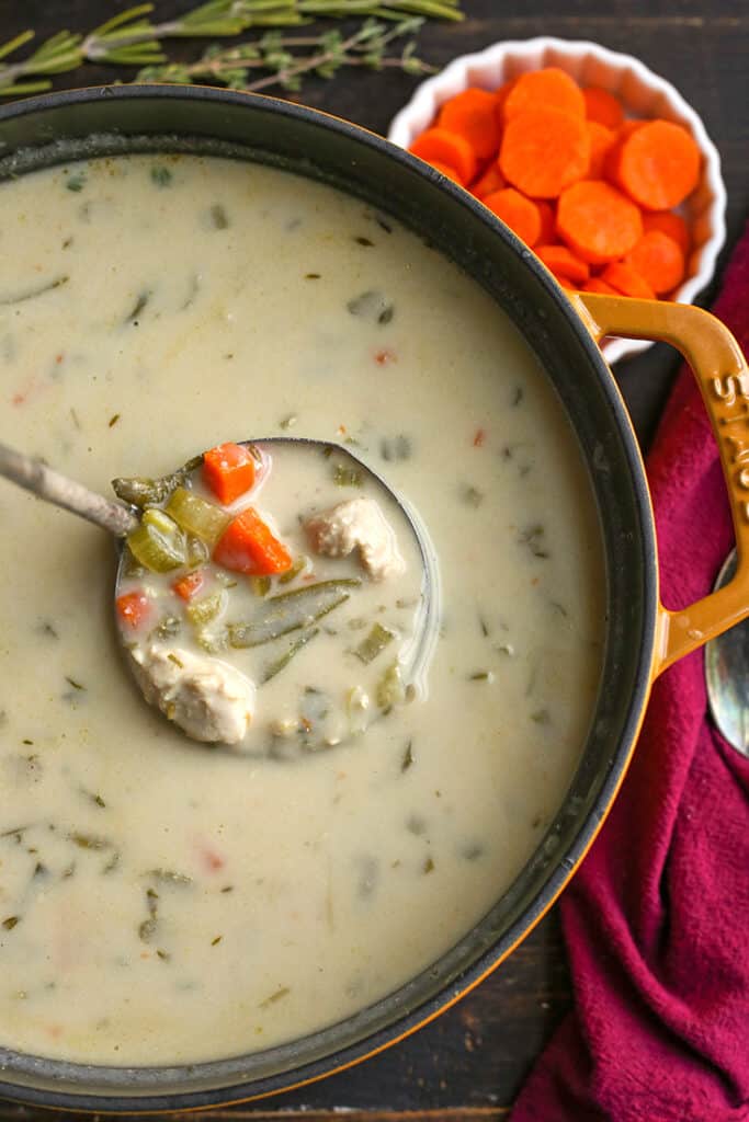 pot of paleo gluten free creamy chicken soup with a ladle taking a scoop 