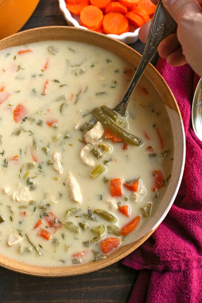 paleo creamy chicken soup with a soup taking a bite 