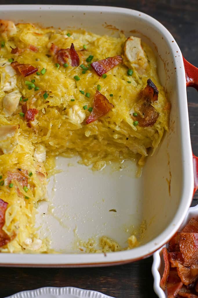 a pan of paleo whole30 chicken bacon ranch casserole with a serving removed so the layers are shown