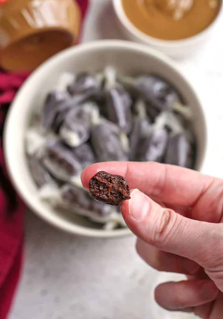 hand holding a paleo tootsie roll with a bite taken out 