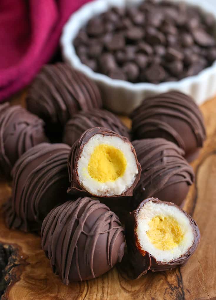 a pile of paleo cadbury creme eggs, one cut in half with the center showing 