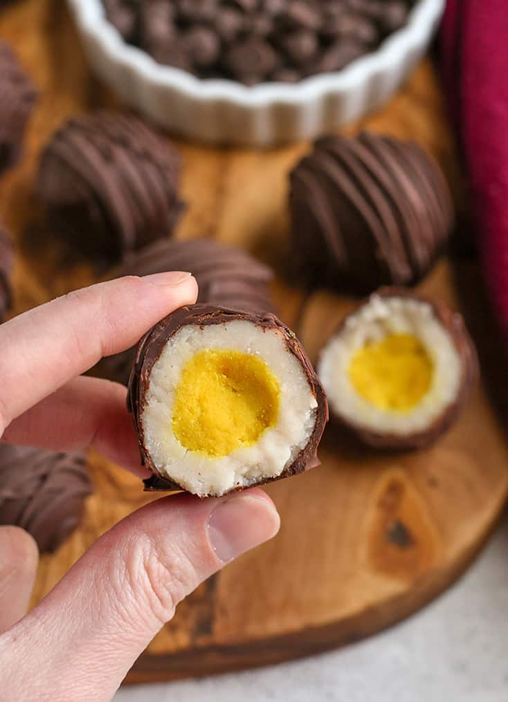 hand holding a paleo vegan cadbury creme egg with the middle showing 
