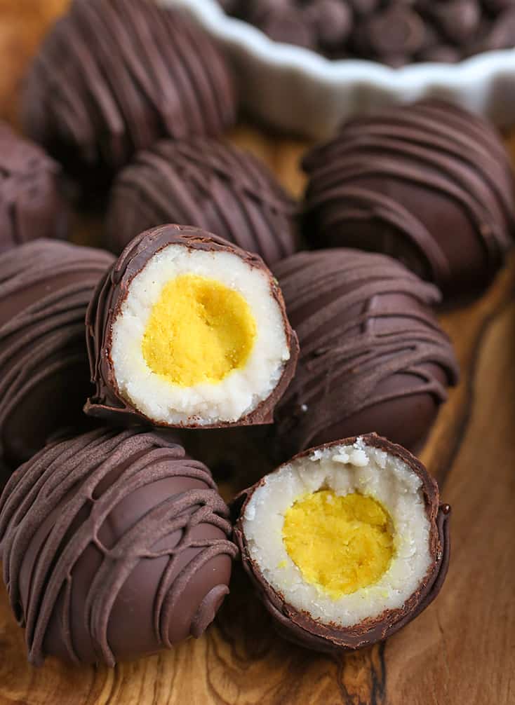 a close up of a stack of paleo cadbury creme eggs, one cut with the center showing