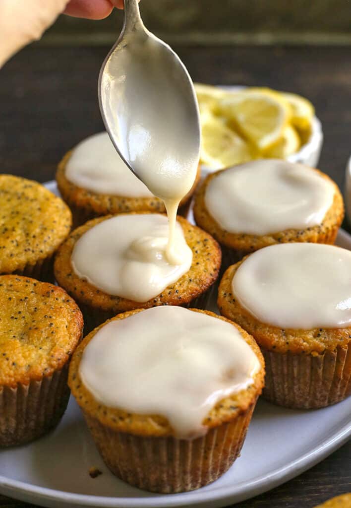 glaze being dripped onto a lemon poppy seed olive oil muffin 