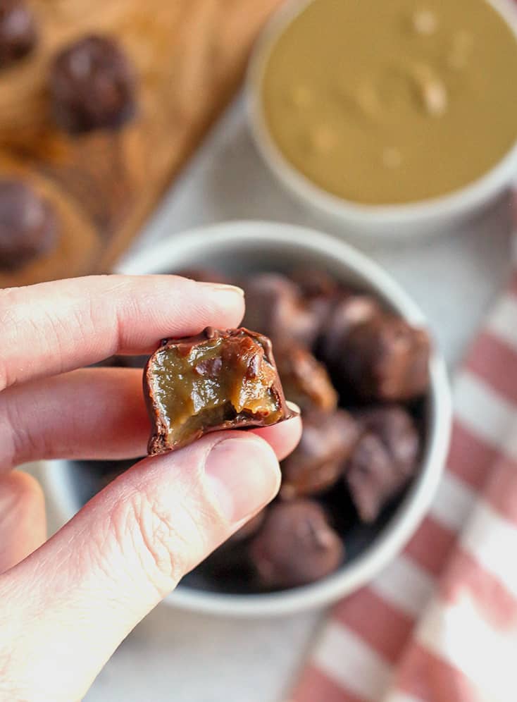 hand holding a paleo vegan rolo with a bite taken out of it 