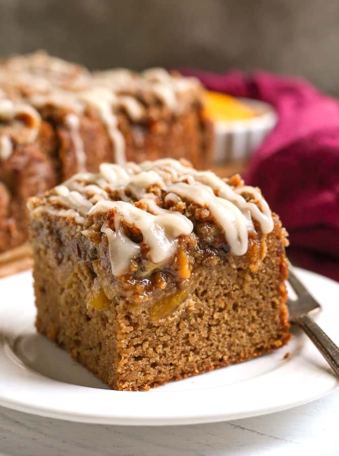 a piece of paleo peach coffee cake on a small plate with a fork