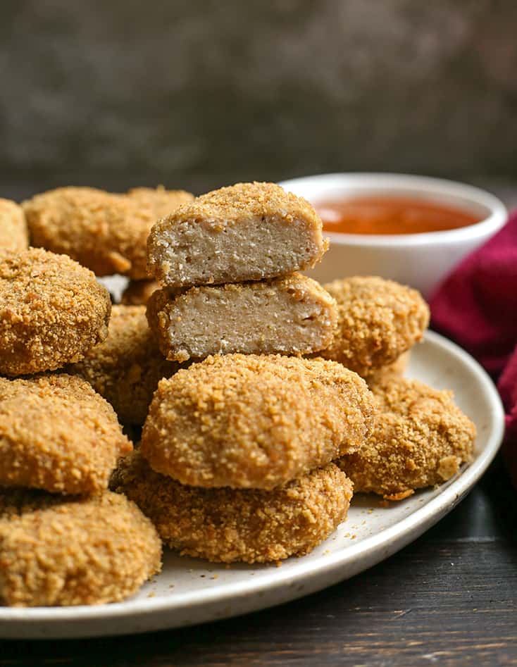 a plate of paleo chicken nuggets with one cut in half and the center showing 