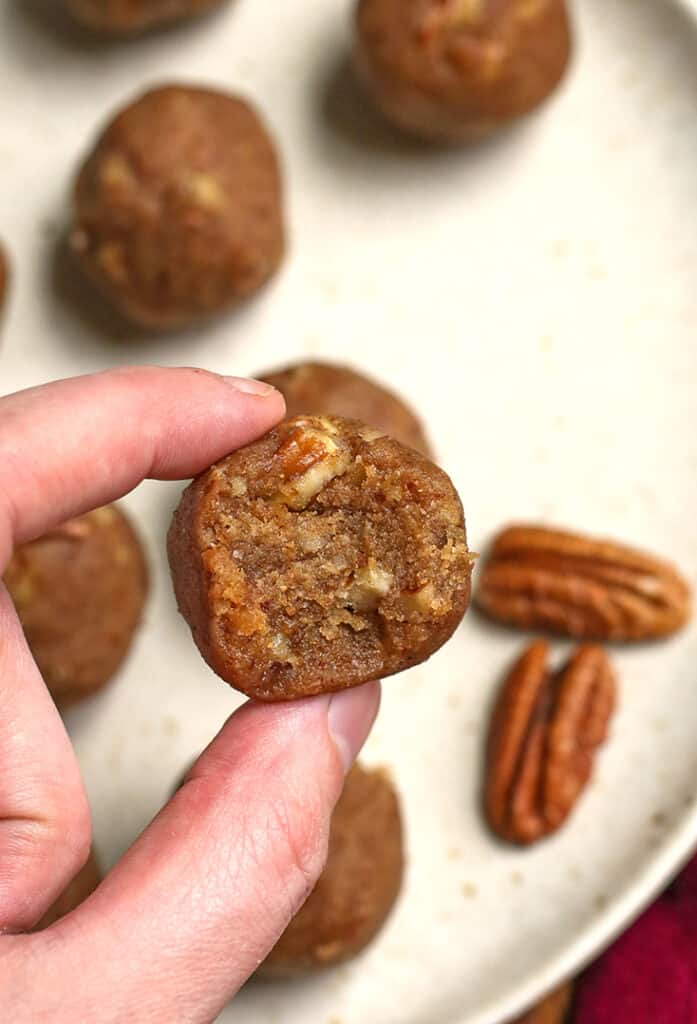 hand holding a paleo pecan pie bite with a bite taken out of it 