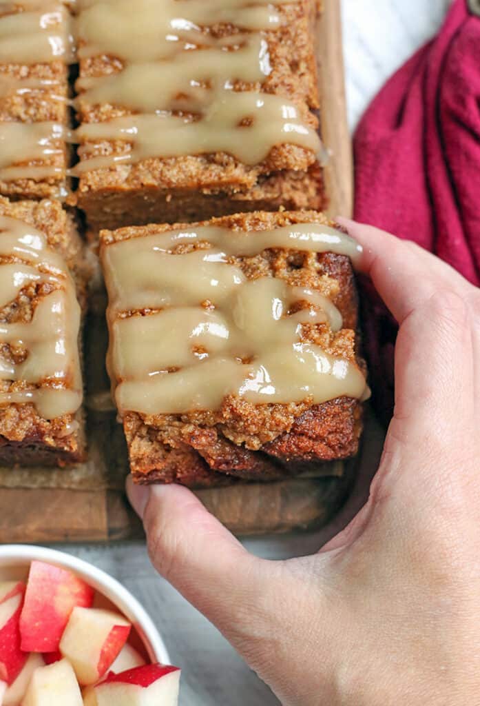 hand reaching for a piece of paleo apple crisp coffee cake 