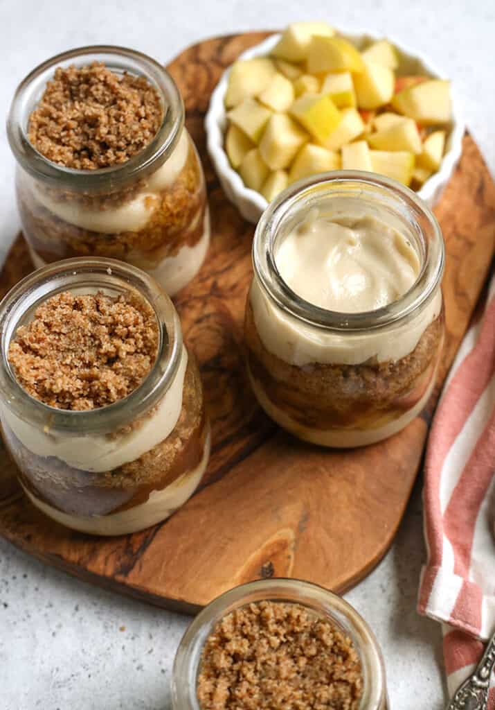 four paleo caramel apple parfaits sitting on a cutting board