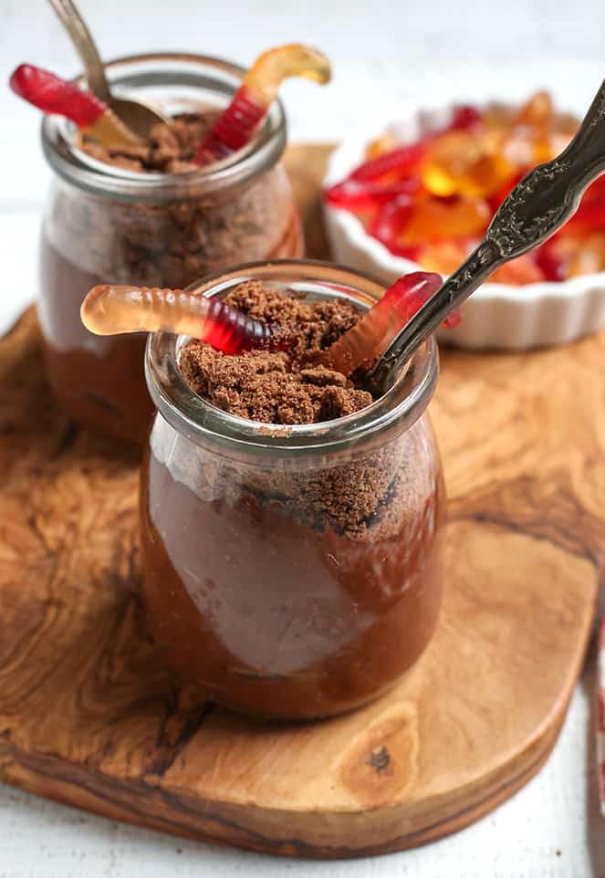 paleo chocolate dirt pudding cups with a spoon in it