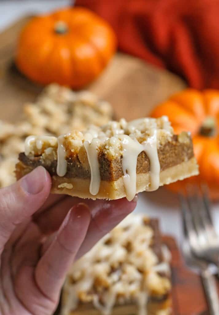 a hand holding a paleo vegan pumpkin pie crumb bar