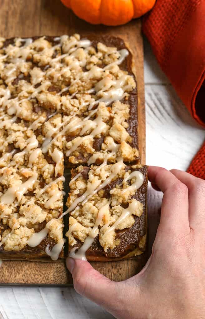 hand reaching for a paleo pumpkin crumb bar