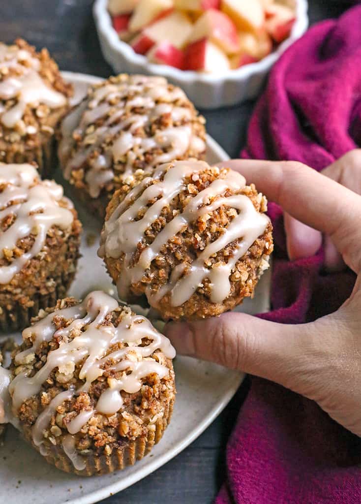 hand grabbing a gluten free applesauce muffin off a plate 