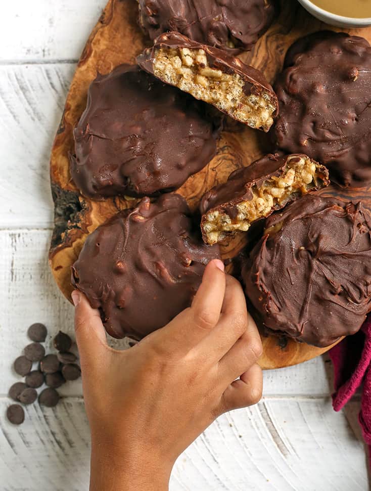 small hand reaching for a gluten free star crunch cookie from a cutting board