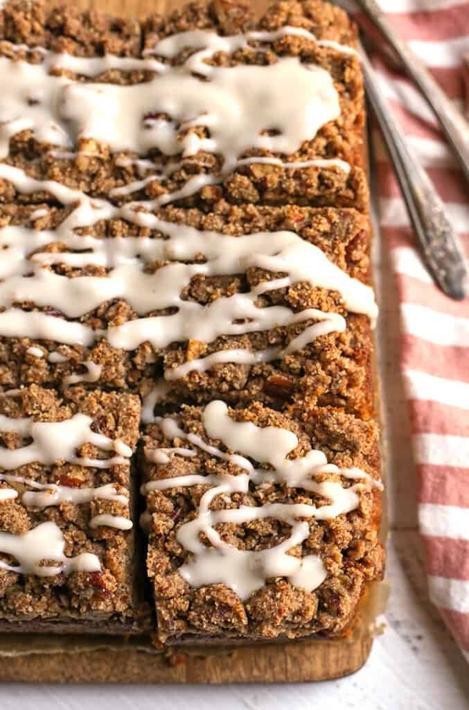 paleo sweet potato pecan coffee cake on a cutting board, glaze on top 