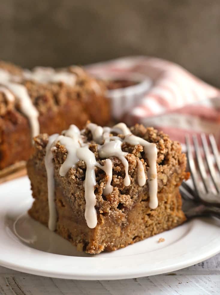 a piece of sweet potato coffee cake on a plate with glaze dripping down 